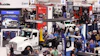 Busy trade show floor with white commercial truck display and multiple vendor booths showcasing automotive and truck equipment brands.