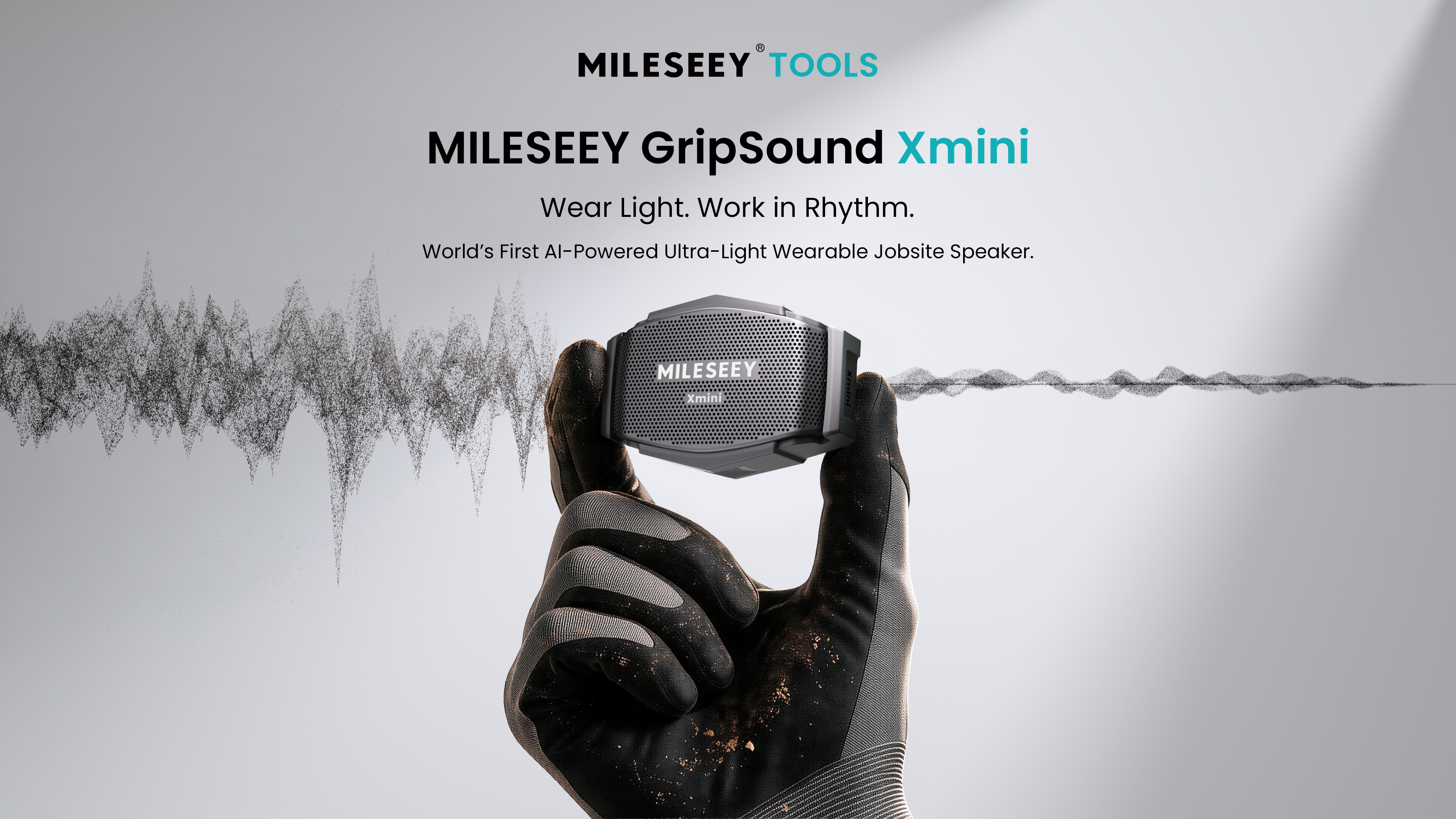MILESEEY GripSound Xmini ultra-light wearable jobsite speaker held in gloved hand with sound waveform visualization